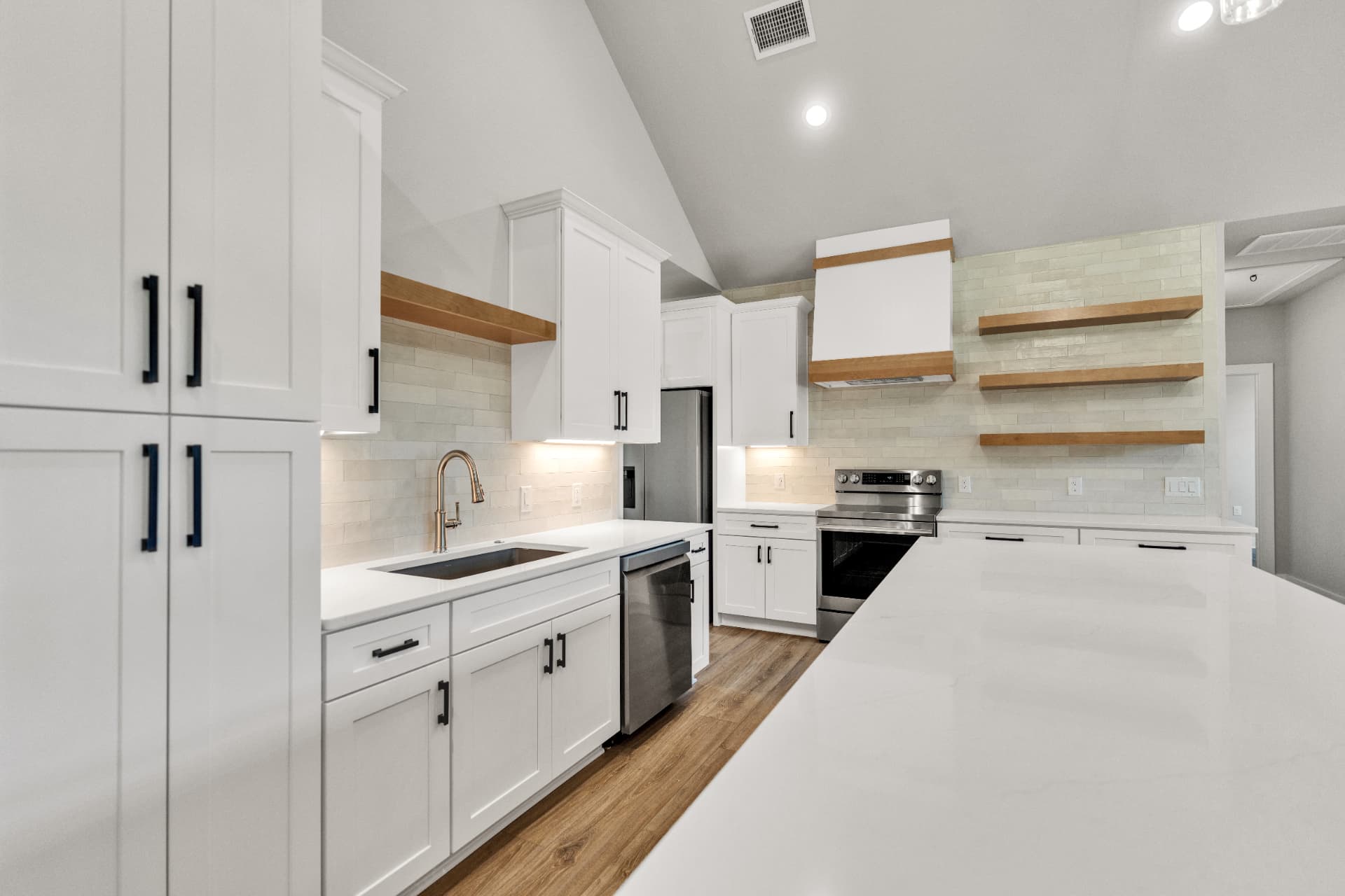 Brinley Barndominium kitchen with white cabinetry, quartz counters, and white oak shelving